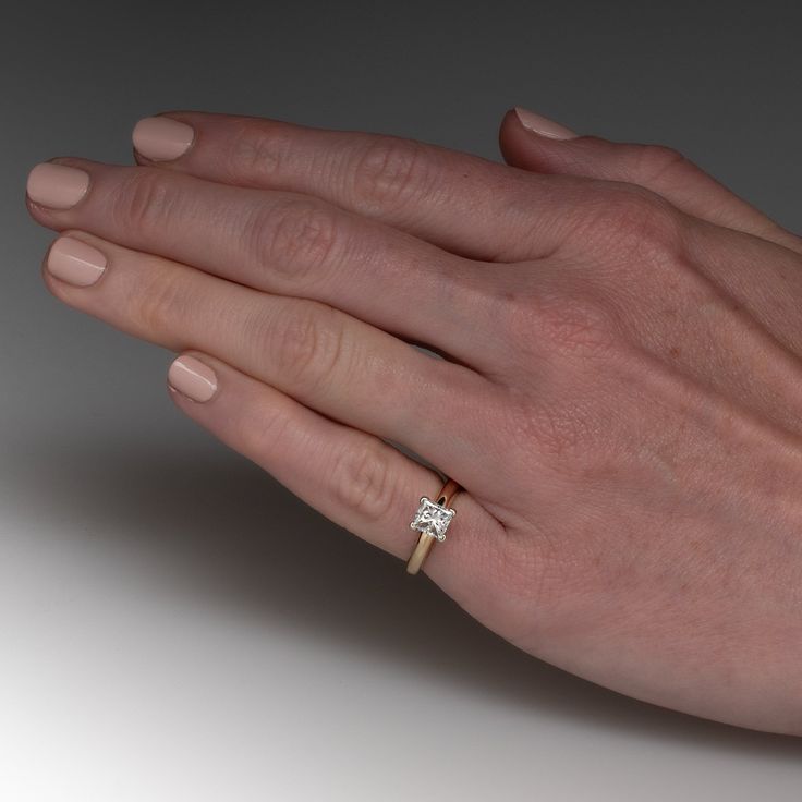 a woman's hand with a diamond ring on it