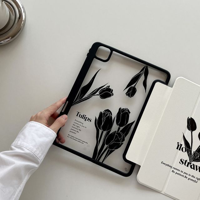 a person holding an ipad case with flowers on it