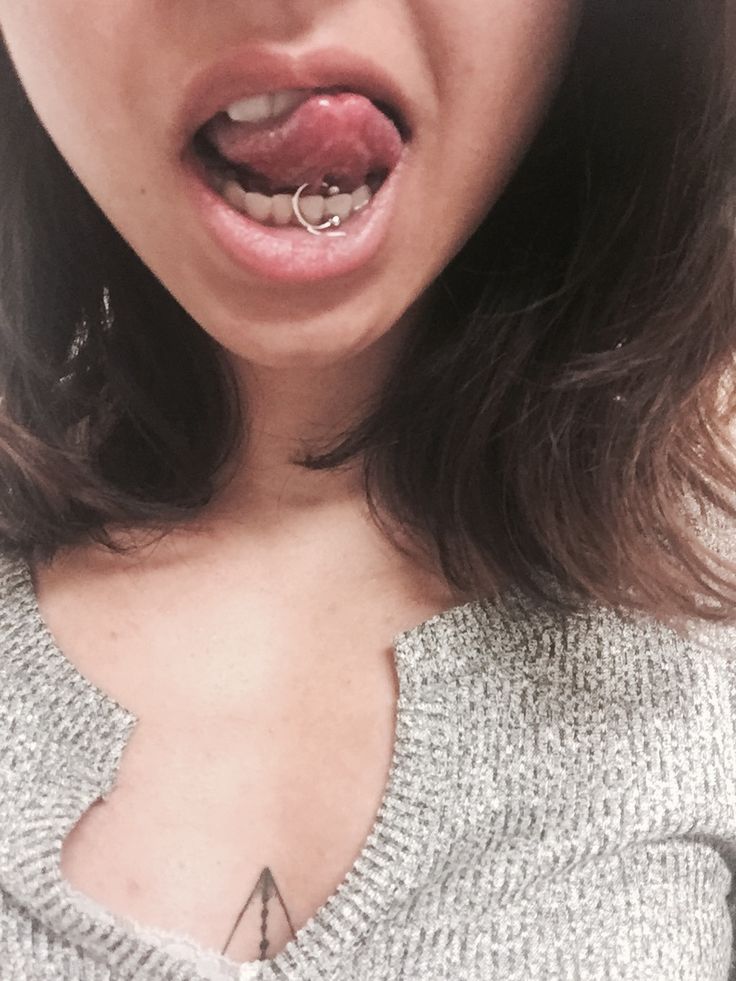 a close up of a person with a piercing on her lip and wearing a sweater