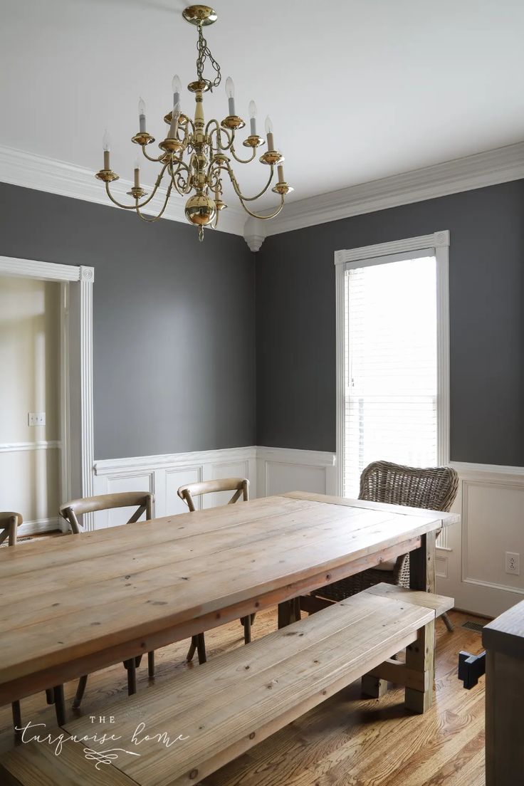 a dining room table with benches in front of it and a chandelier hanging from the ceiling