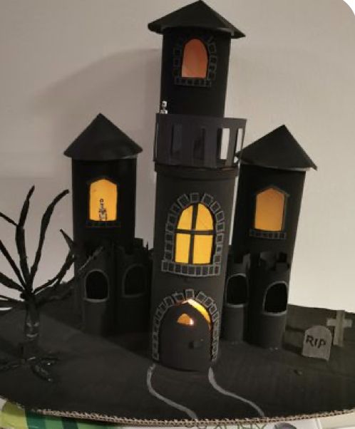 there is a black castle made out of paper and some lights on the top of it