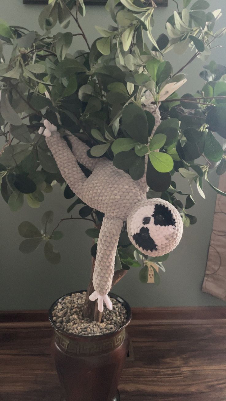 a stuffed animal is on top of a potted plant