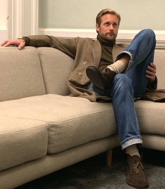 a man sitting on top of a white couch