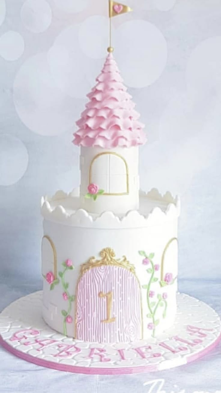 a white cake with pink frosting and a princess castle on top