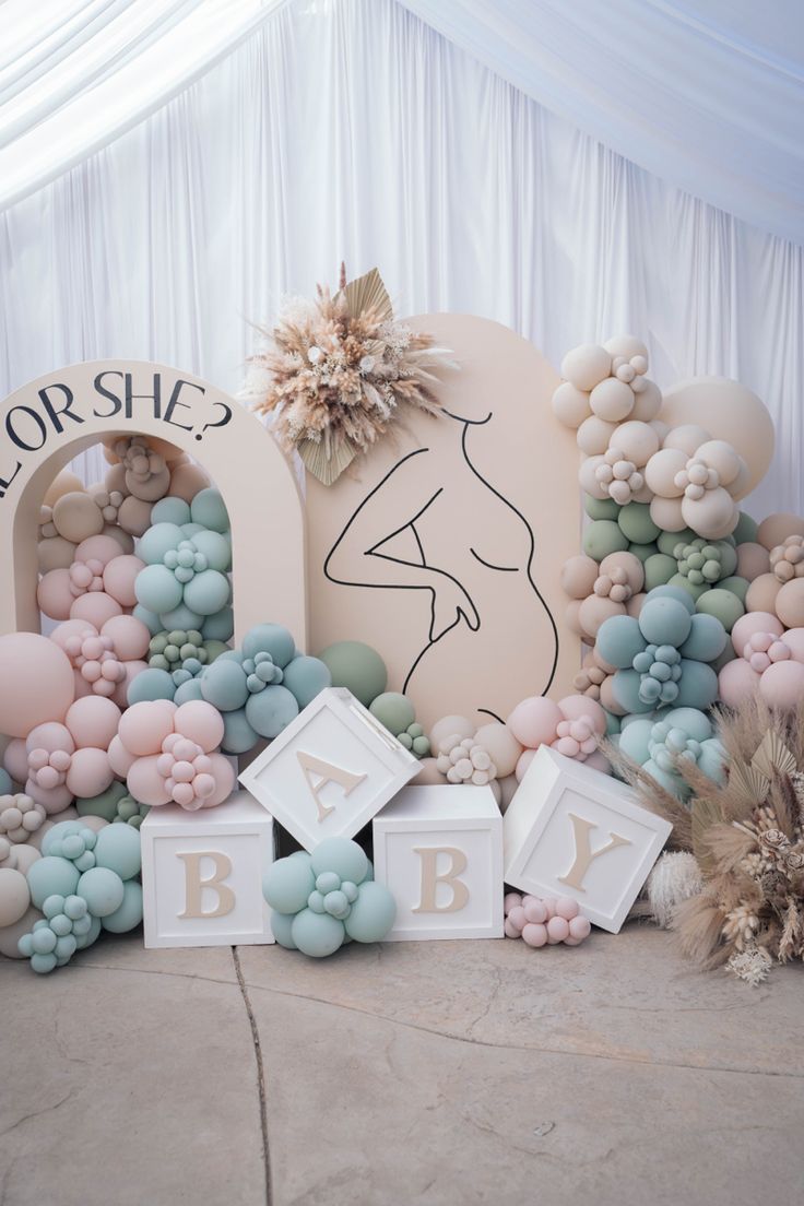 a baby shower sign surrounded by balloons and flowers