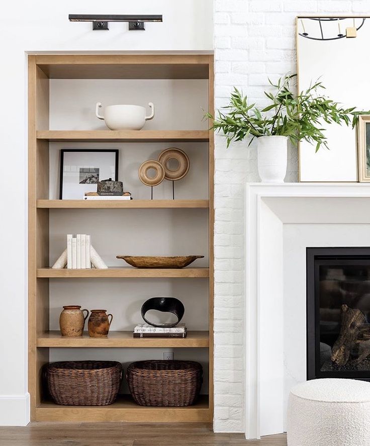 a living room filled with furniture and a fire place in front of a white brick wall