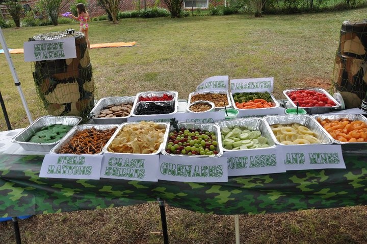 a table topped with lots of different types of food on top of a grass covered field