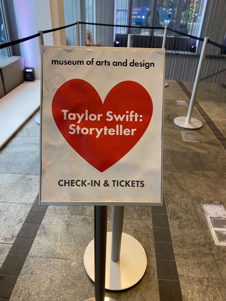 a sign that says taylor swift storyteller check - in and tickets on it