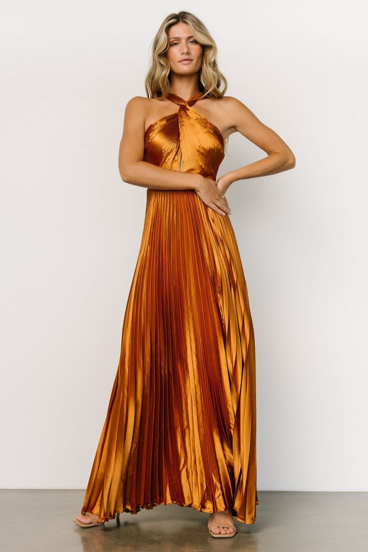 Stand out in our flattering Sandra Pleated Maxi Dress that comes in a Copper color. This dress will make you feel like a statement in any room! Satin Dress With Tie Back And Cross Back, Halter Dress With Crisscross Straps For Party, Night Out Dress With Tie Back And Crisscross Shape, Sleeveless Satin Dress With Crisscross Straps, Fitted Cross Back Halter Dress For Party, Chic Satin Dress With Crisscross Straps, Pleated Brown Dress For Date Night, Fitted Cross Back Maxi Dress For Party, Satin Cross Back Evening Dress