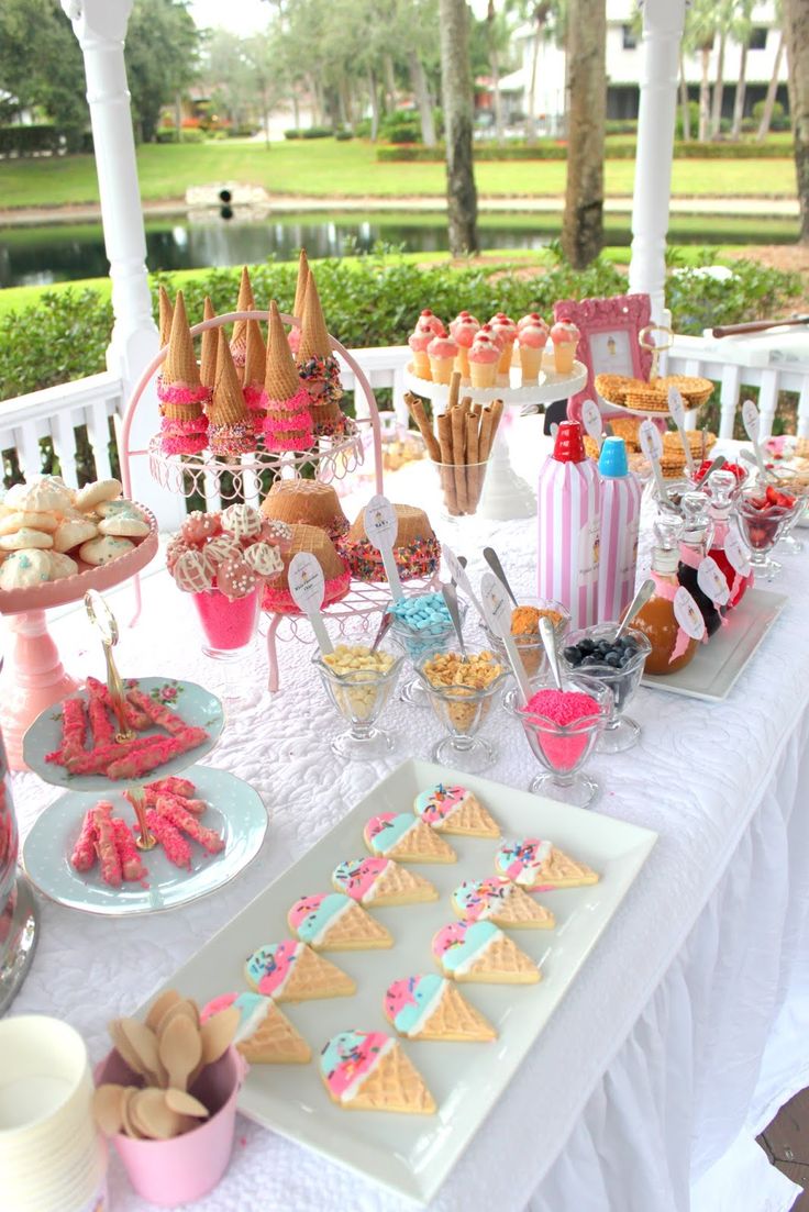 a white table topped with lots of desserts and snacks on top of it's own