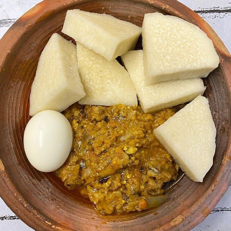 a wooden bowl filled with food on top of a table