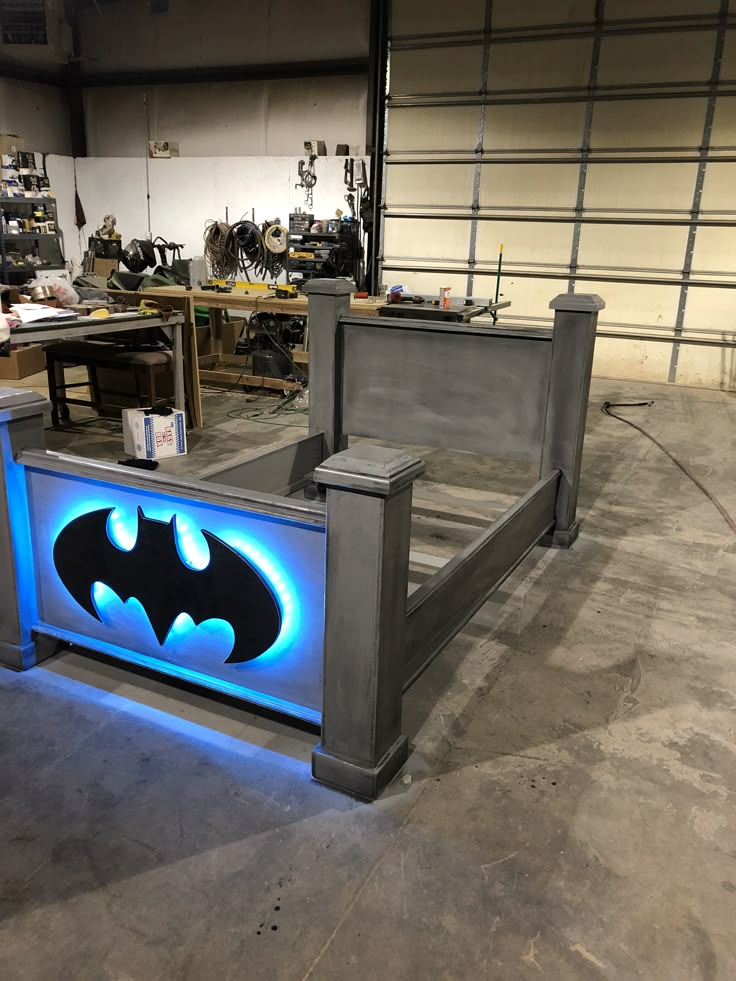 a batman bed frame is lit up with blue lights