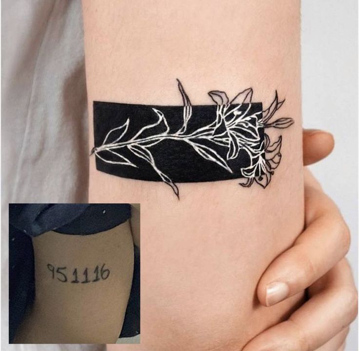 a woman's arm with a tattoo on it that has flowers and leaves on it