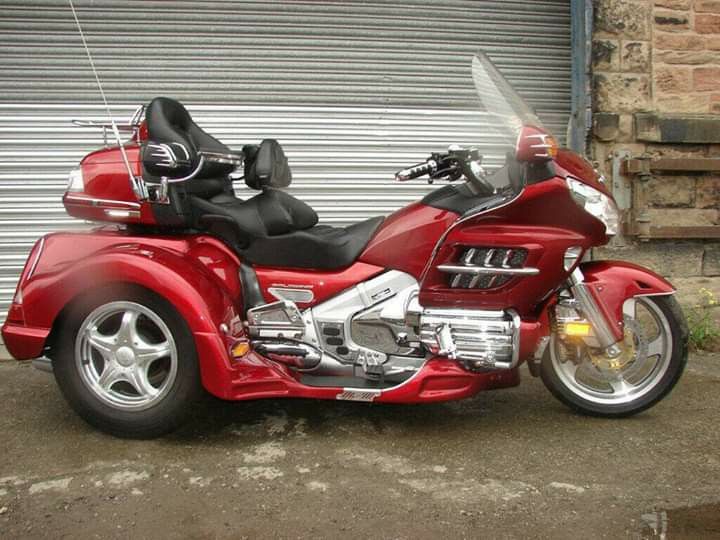 a red motorcycle parked in front of a garage door