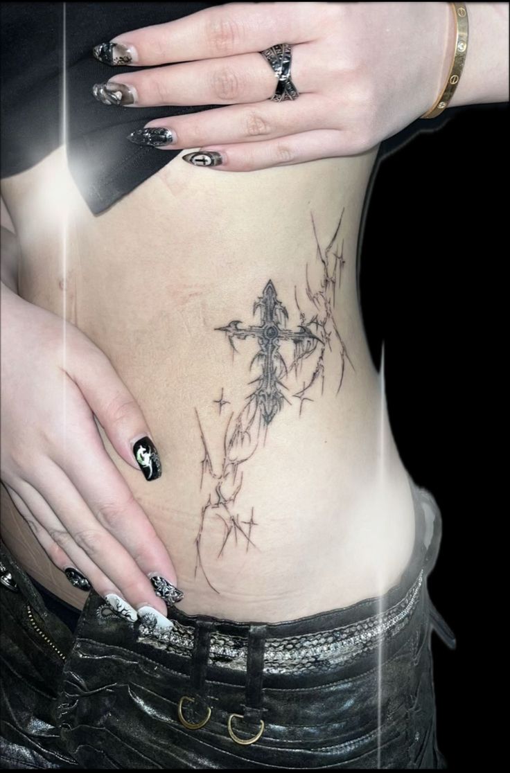 a woman's stomach with tattoos and piercings on her belly is seen in this image