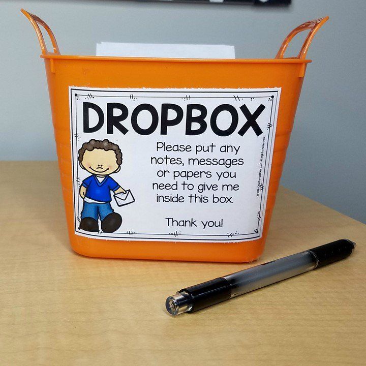 an orange bucket with a sign that says dropbox on it next to a pen