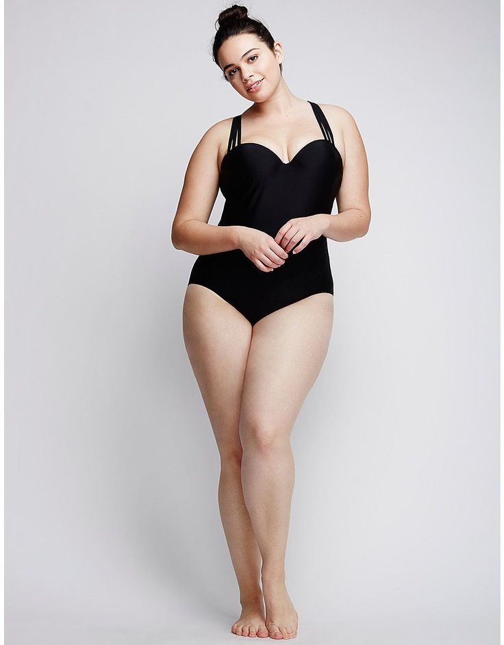 a woman in a black one piece swimsuit posing for the camera with her hands on her hips