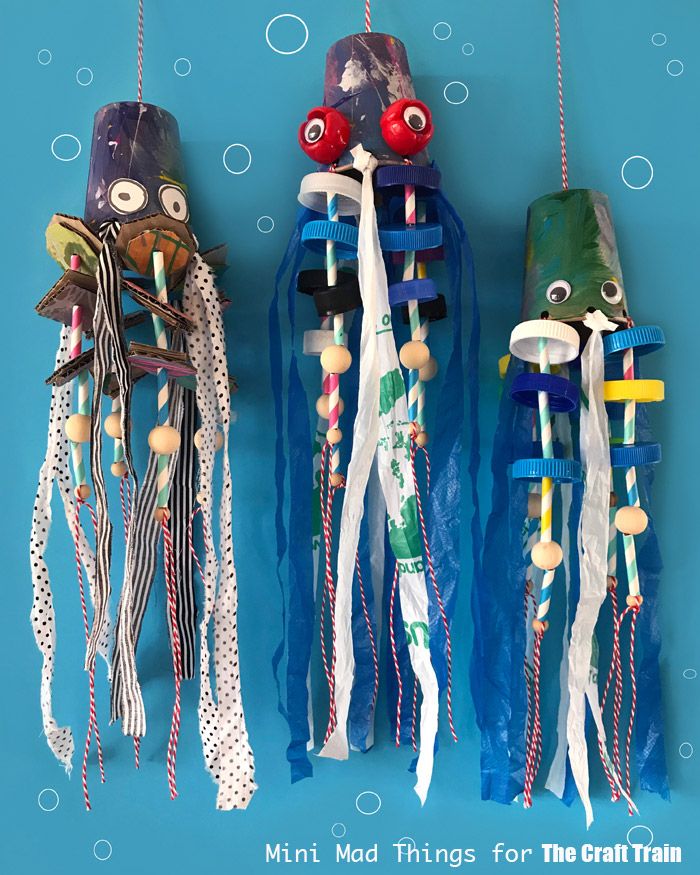 three colorful items hanging from strings on a blue background with words mini mad things for the craft train