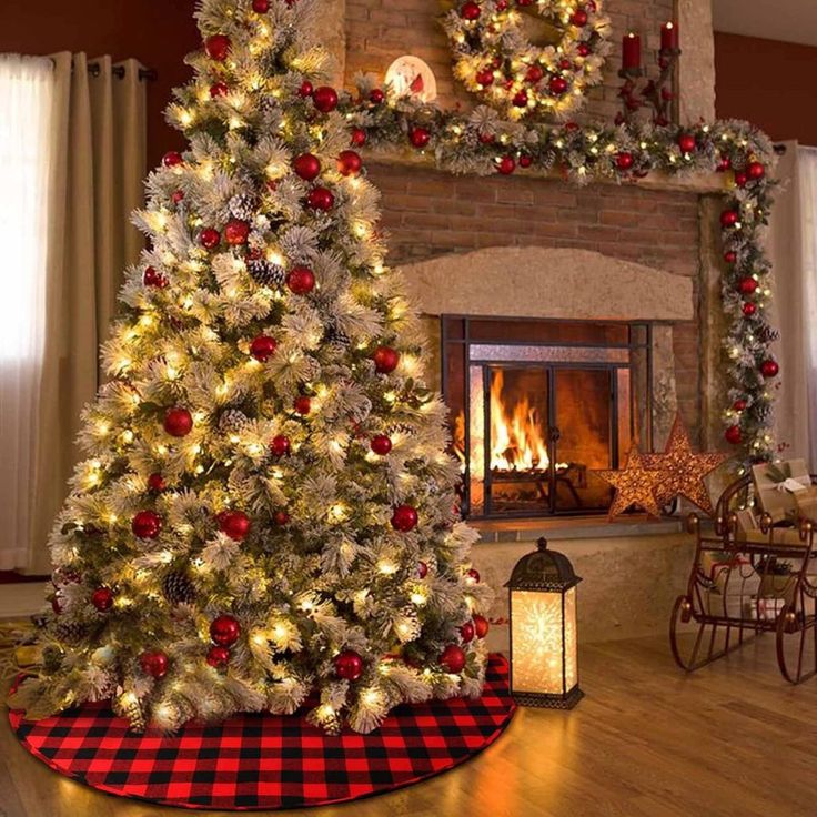 a decorated christmas tree in front of a fireplace