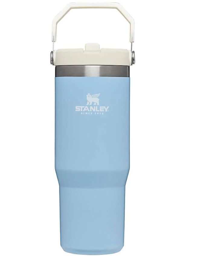 the stanley stainless steel insulated water bottle is light blue with a white lid and handle