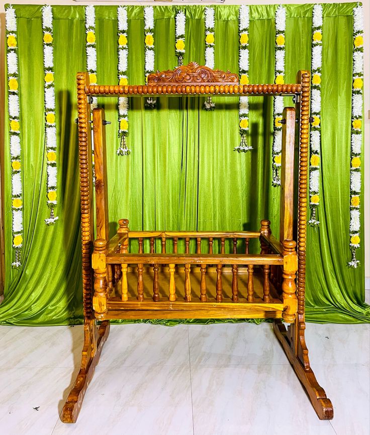 a wooden bed frame sitting in front of a green curtain