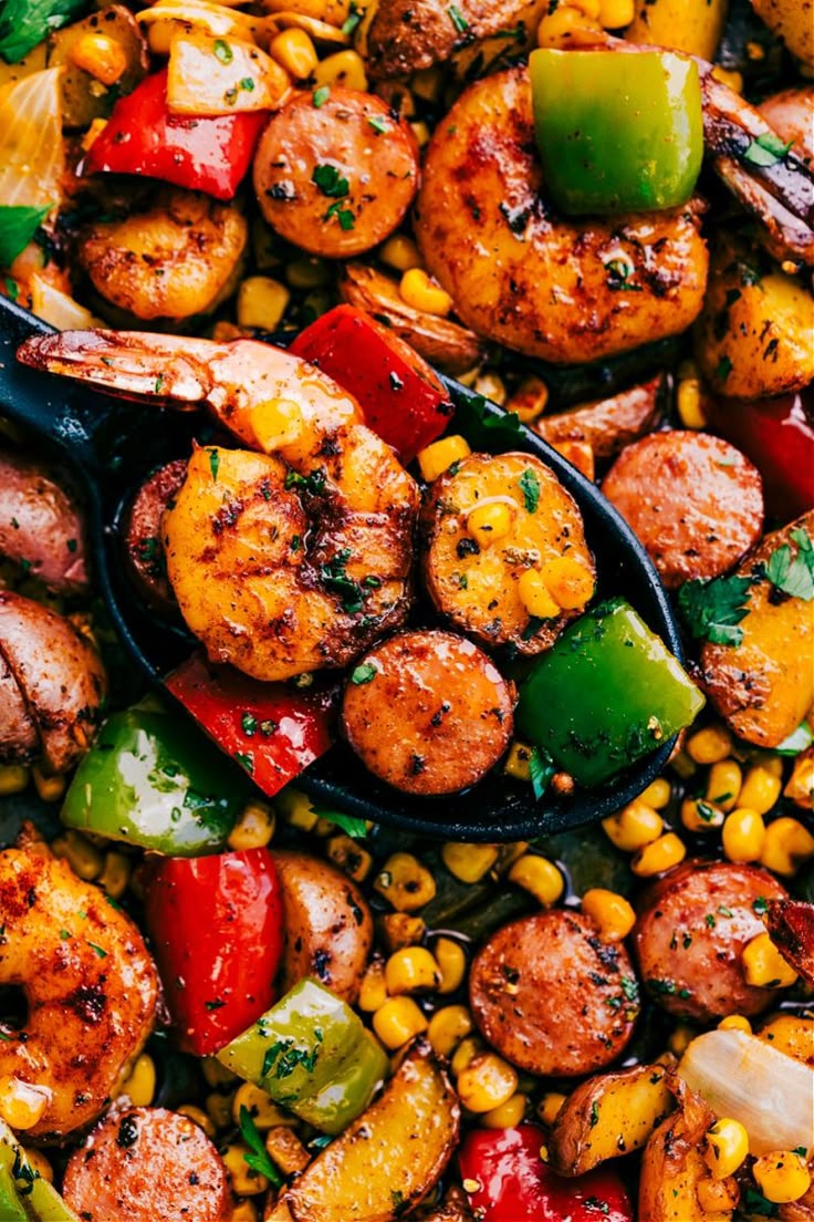 a pan filled with shrimp, corn and peppers