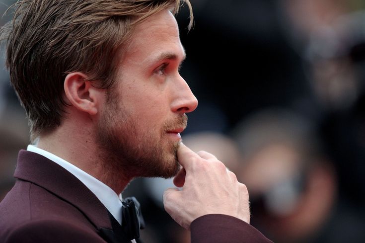 a close up of a person wearing a suit and tie looking off to the side