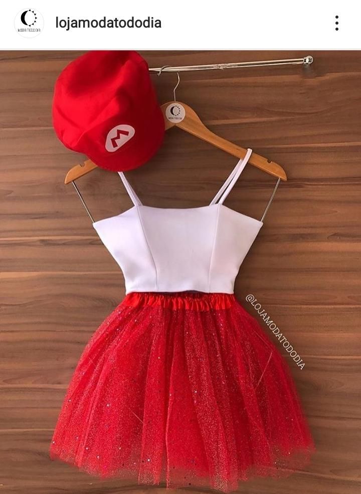 a red and white dress with a hat hanging on a wooden wall next to a hanger