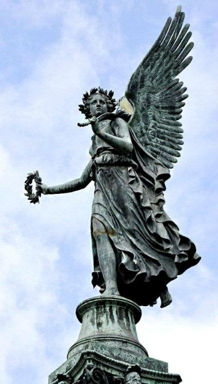 an angel statue on top of a building