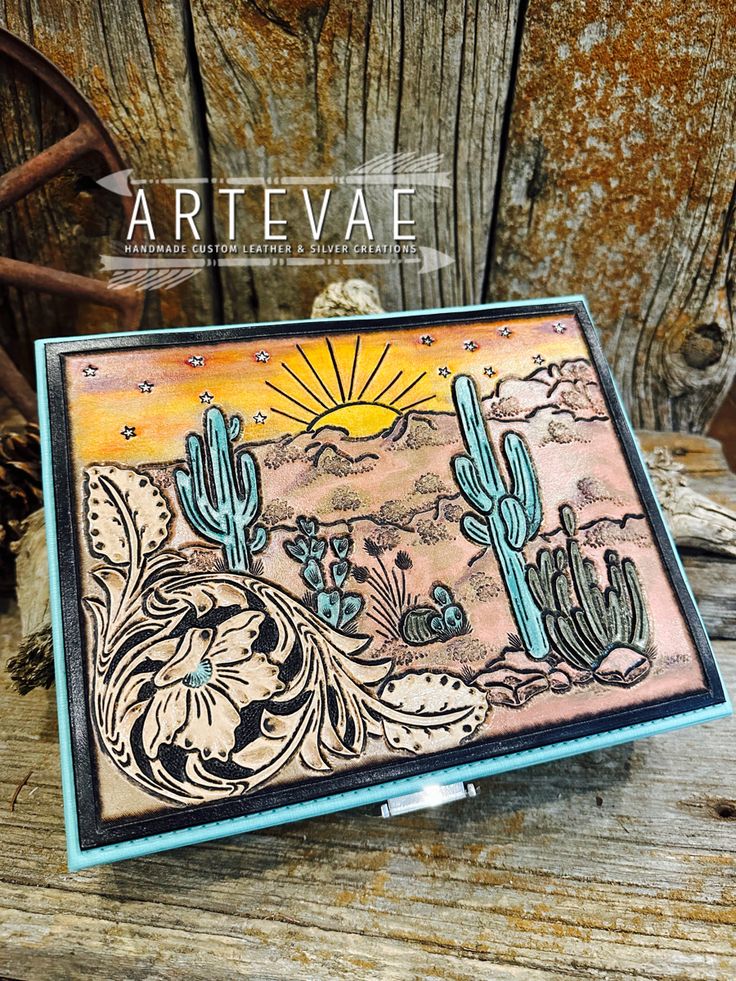 a card with cactus and sun on it, sitting on top of a wooden table