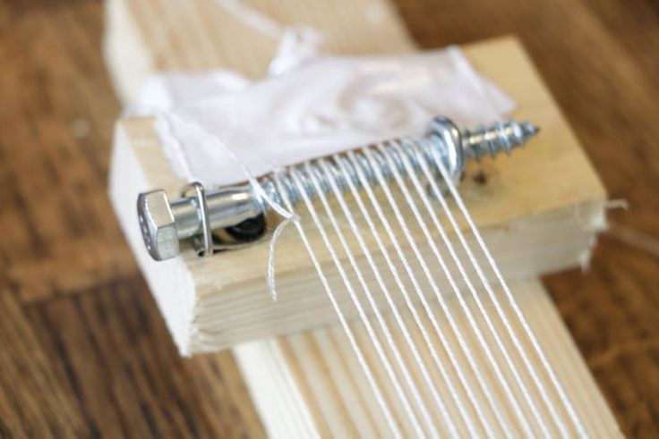 a pair of screws are attached to the side of a piece of wood that is being sewn