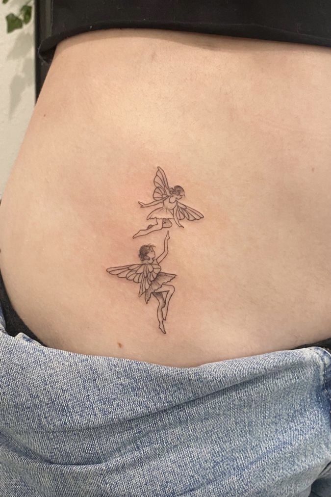 a woman's stomach with a small tattoo on the side of her belly and flowers