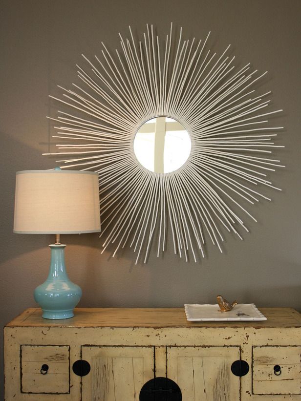 a white dresser sitting next to a lamp on top of a table