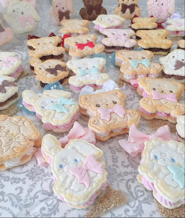 there are many decorated cookies on the table with teddy bears and other items around them