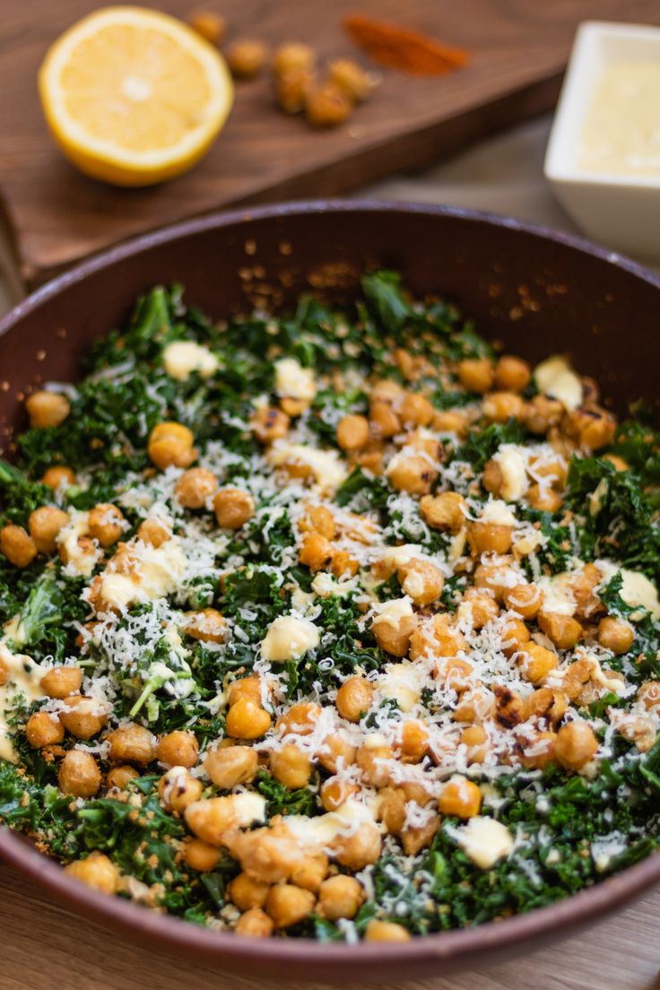 a pan filled with spinach and chickpeas covered in parmesan cheese