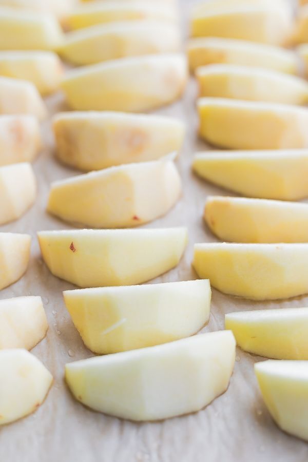 sliced apples on a baking sheet ready to be baked in the oven or used as an appetizer