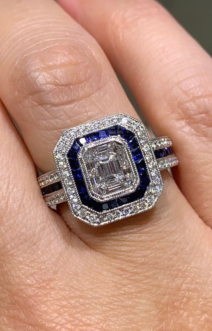 a woman's hand with a diamond and blue sapphire ring