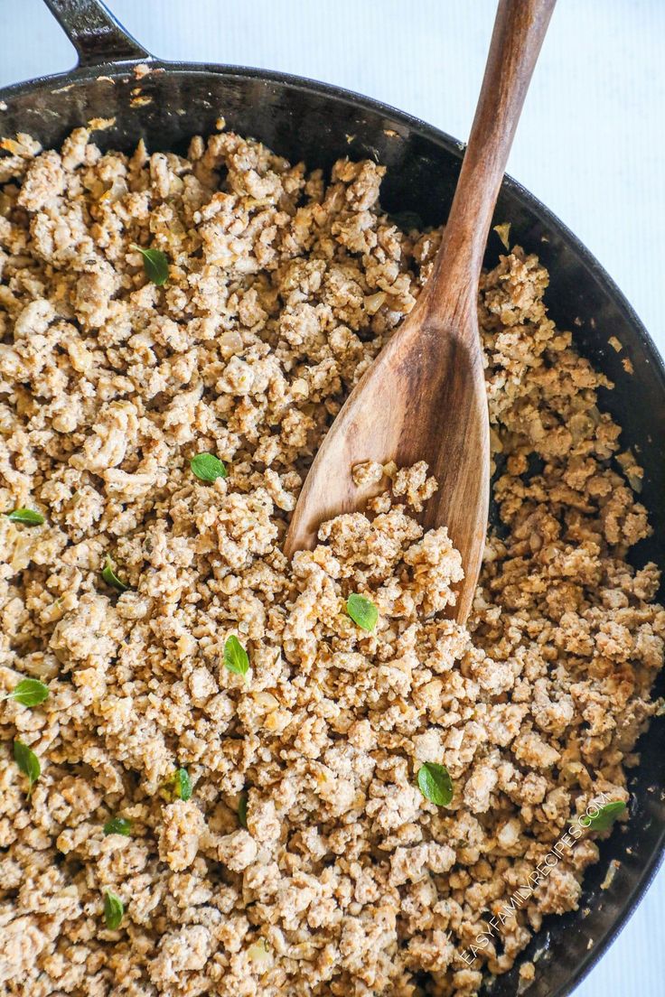 a skillet filled with food and a wooden spoon