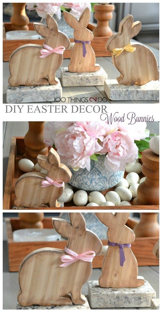 some wooden bunny statues sitting on top of a table with flowers in the middle and an egg