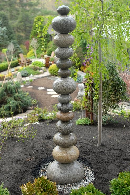 a tall stack of rocks sitting in the middle of a garden