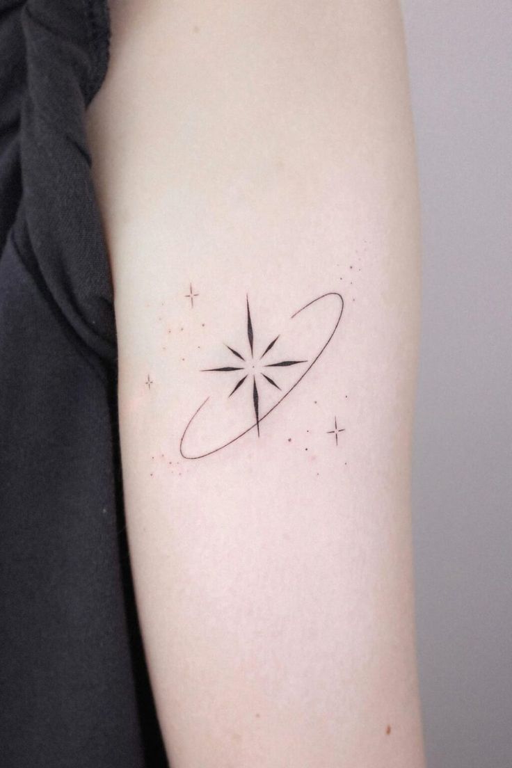 a woman's arm with a small star tattoo on it