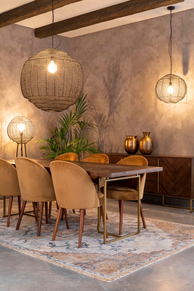 a dining room table surrounded by chairs and lamps with lights hanging from the ceiling above it