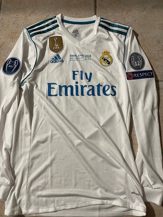 the real madrid home shirt for the 2012 - 2013 season is displayed on the floor