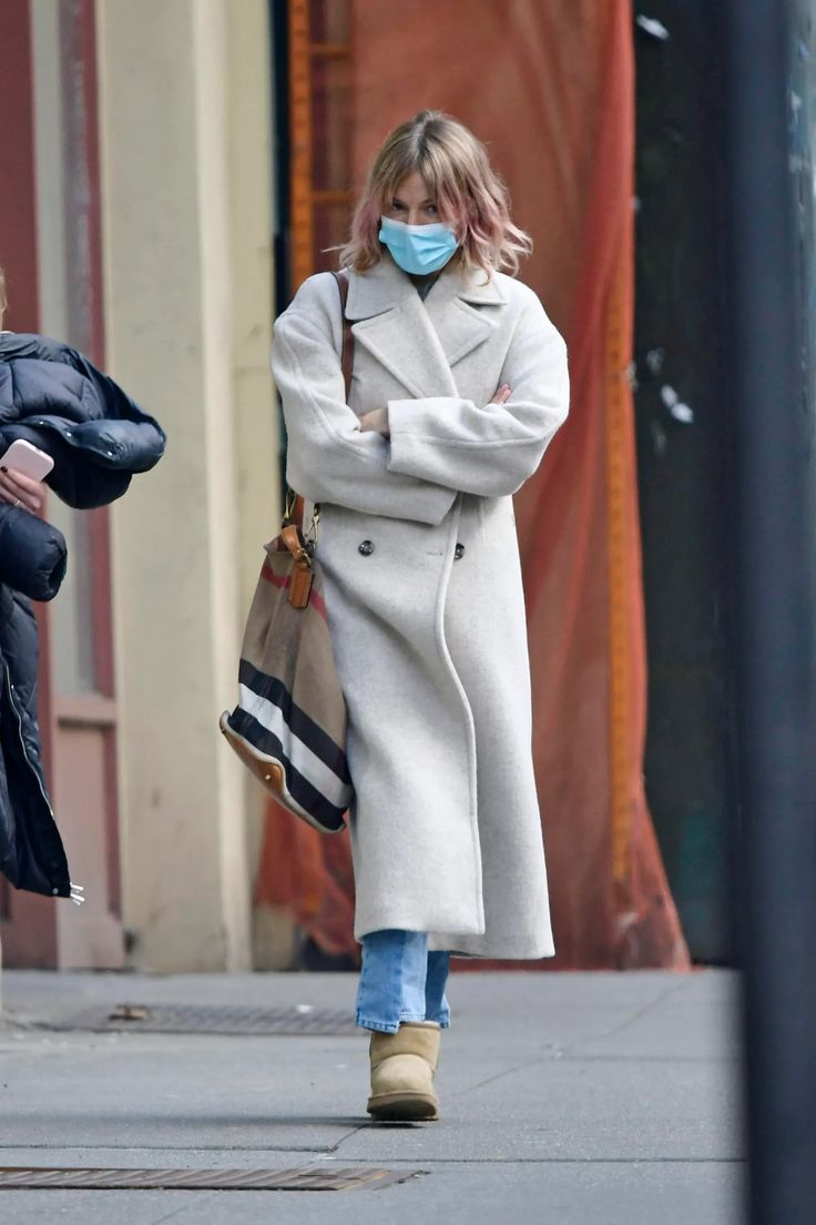 a woman wearing a face mask walking down the street