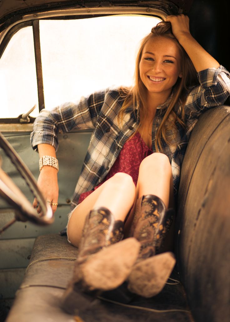 a woman sitting in the back seat of an old truck with her feet on the floor