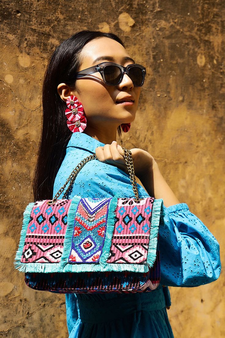 Multi Purpose Shoulder Bag, Intricate Hand Embellished Beadwork In Front Long Metallic Chain Strap Magnetic Button Closure Made In a Beautiful Patterned Hand-Woven Jacquard Fully Lined Interiors With Zip Pocket All Over Fringe Detail In Front Size : 10" X 6" X 3.5" Introducing our Southwest Floral Bloom Beaded Shoulder Bag the perfect accessory for adding a touch of cultural charm to your outfit. This multi-purpose shoulder bag is designed to be both stylish and practical, making it the ideal ch Embellished Multicolor Shoulder Bag, Bohemian Embellished Shoulder Bag, Chic Multicolor Embroidered Bag, Chic Multicolor Beaded Bags, Embellished Multicolor Embroidery Bags, Bohemian Beaded Bags, Bohemian Blue Bags As Fashion Accessory, Summer Bohemian Beaded Shoulder Bag, Bohemian Embellished Bags For Vacation