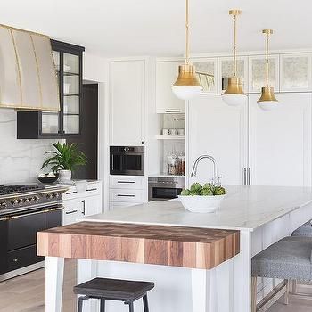 a kitchen with white cabinets and an island in front of the stove, oven and sink