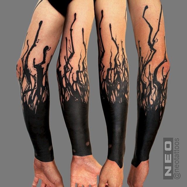 the legs and arms are covered in black ink, with trees on both sides of them