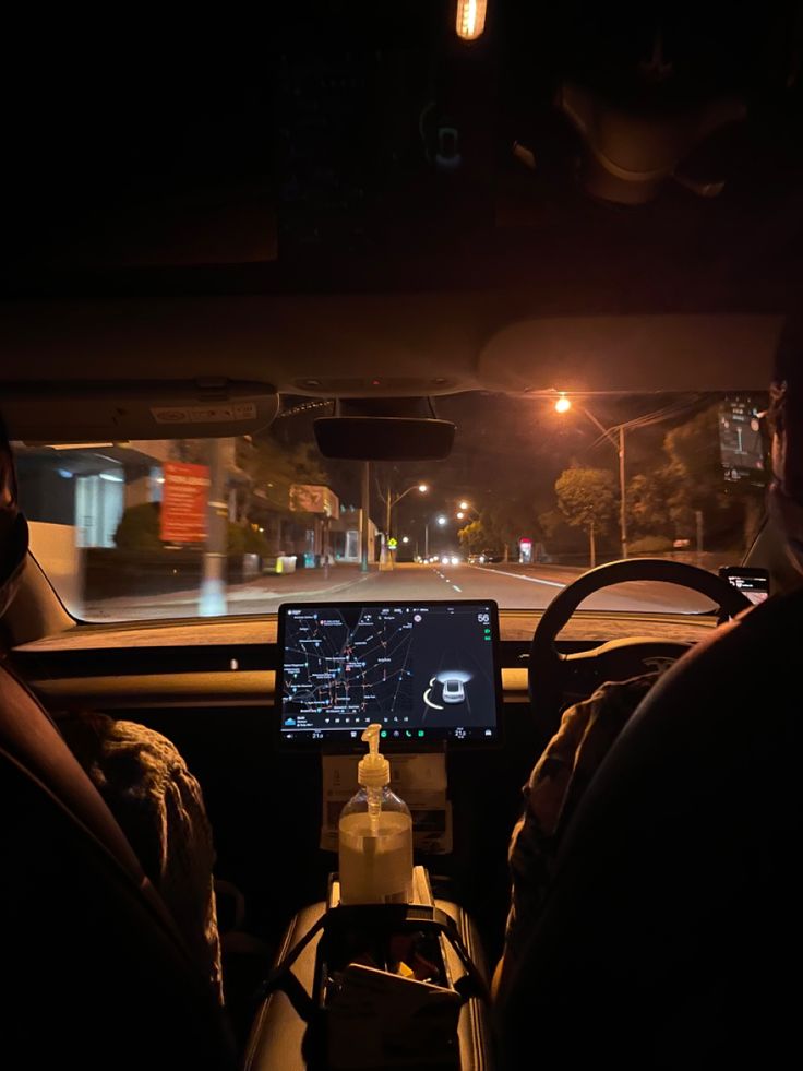 two people sitting in the passenger seat of a car at night