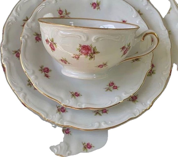 an antique tea cup and saucer set with pink roses on white, gold trimmings